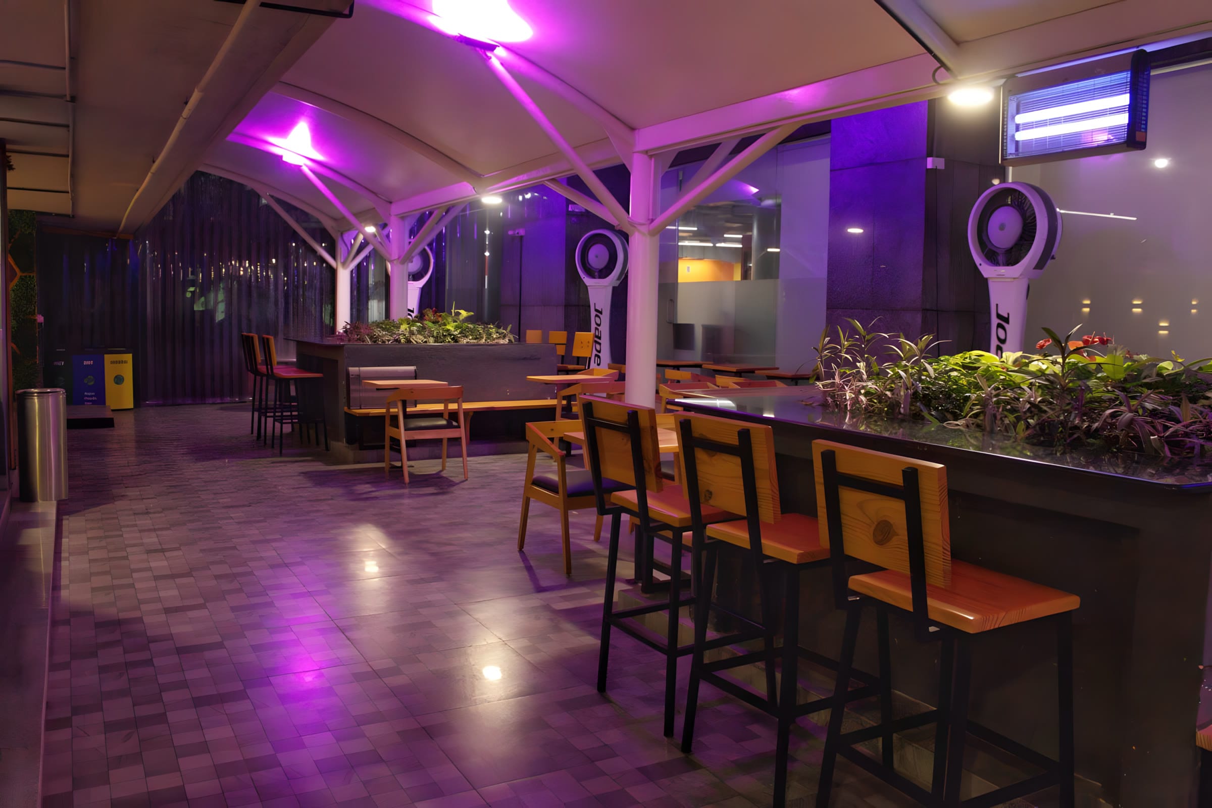 Covered cafeteria with bar seating and planters at Flock office