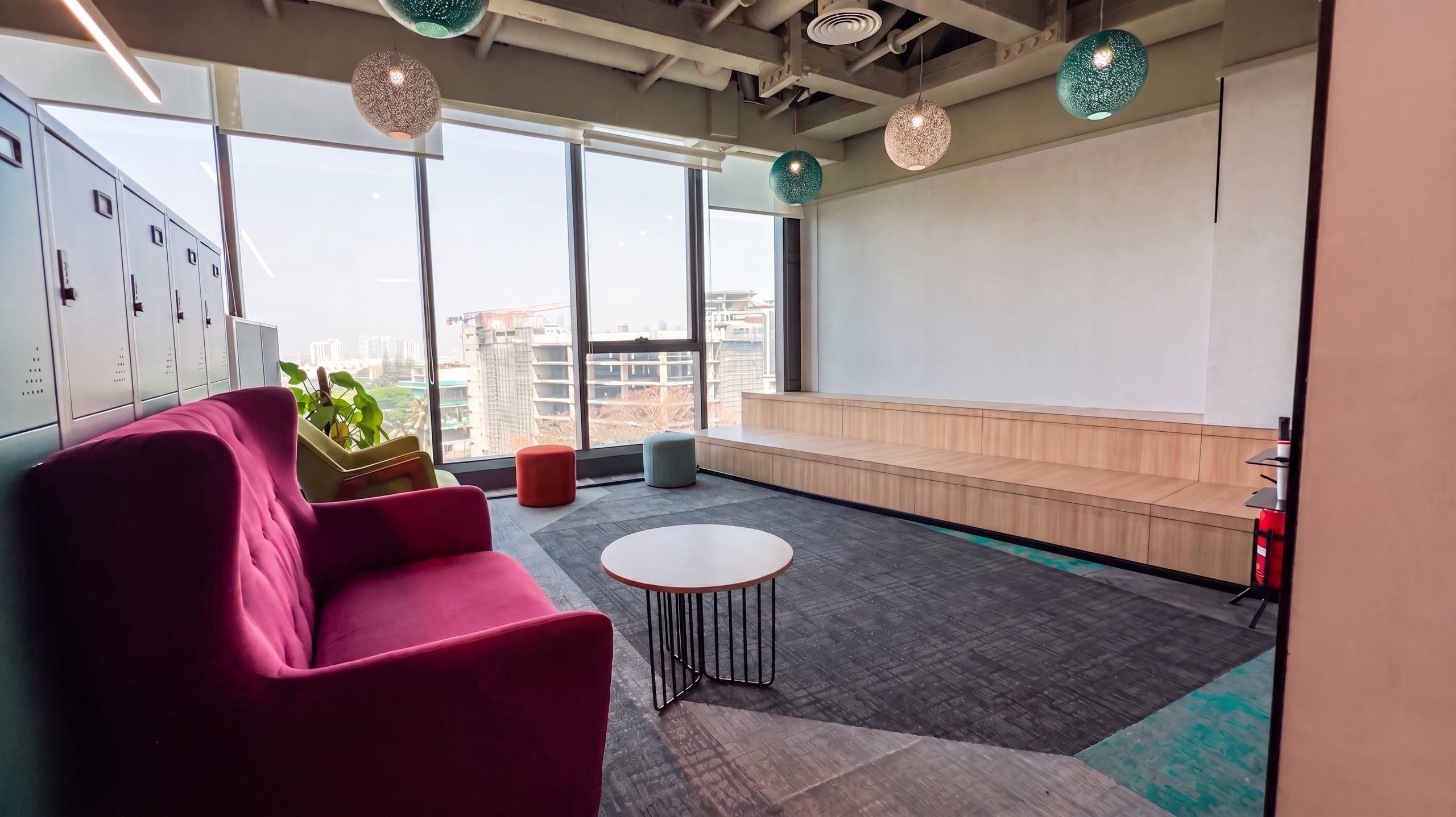 Breakout area with red sofa and hanging lights at HPE office