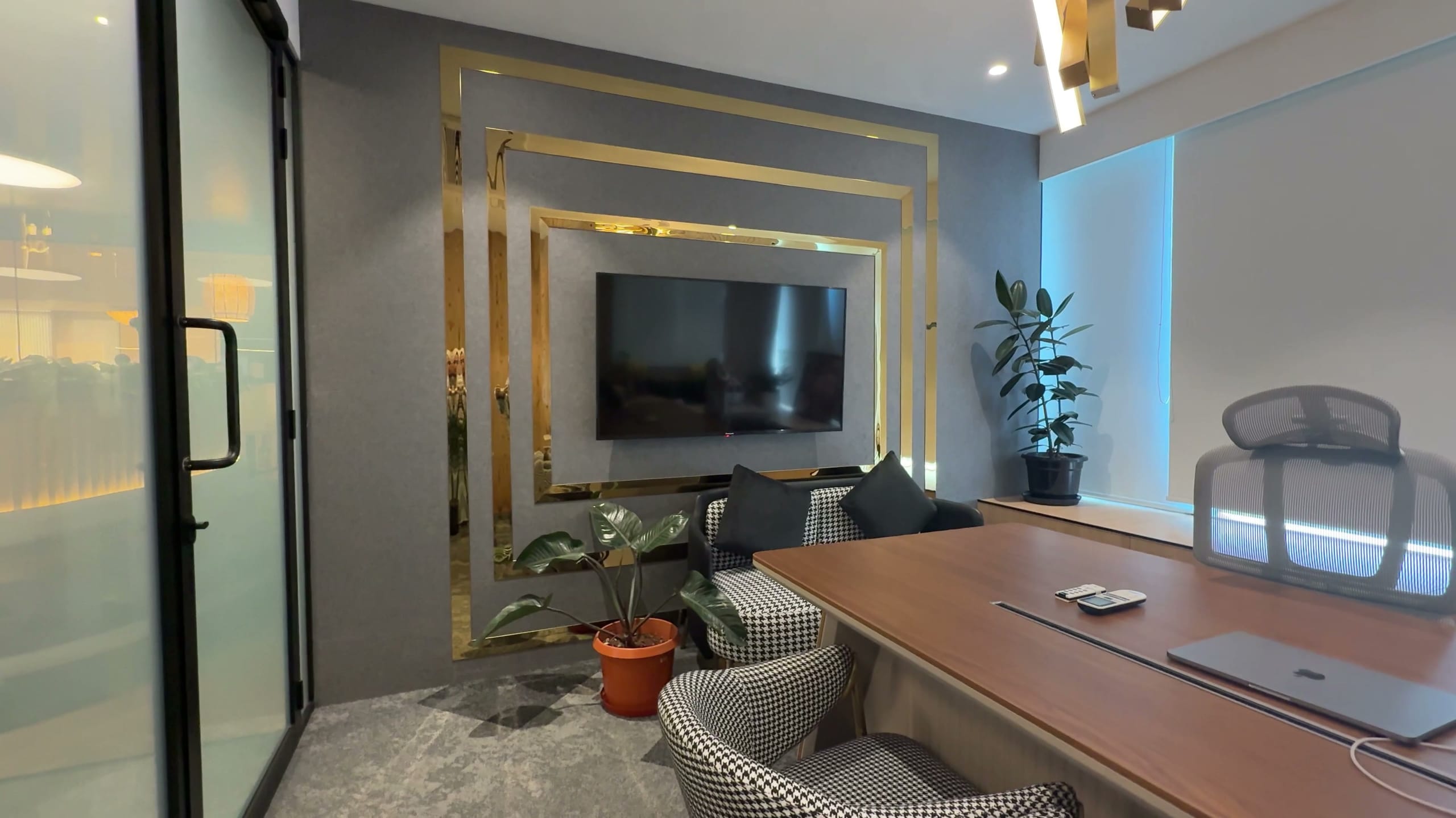 Director's cabin with wall-mounted screen at Rugr office