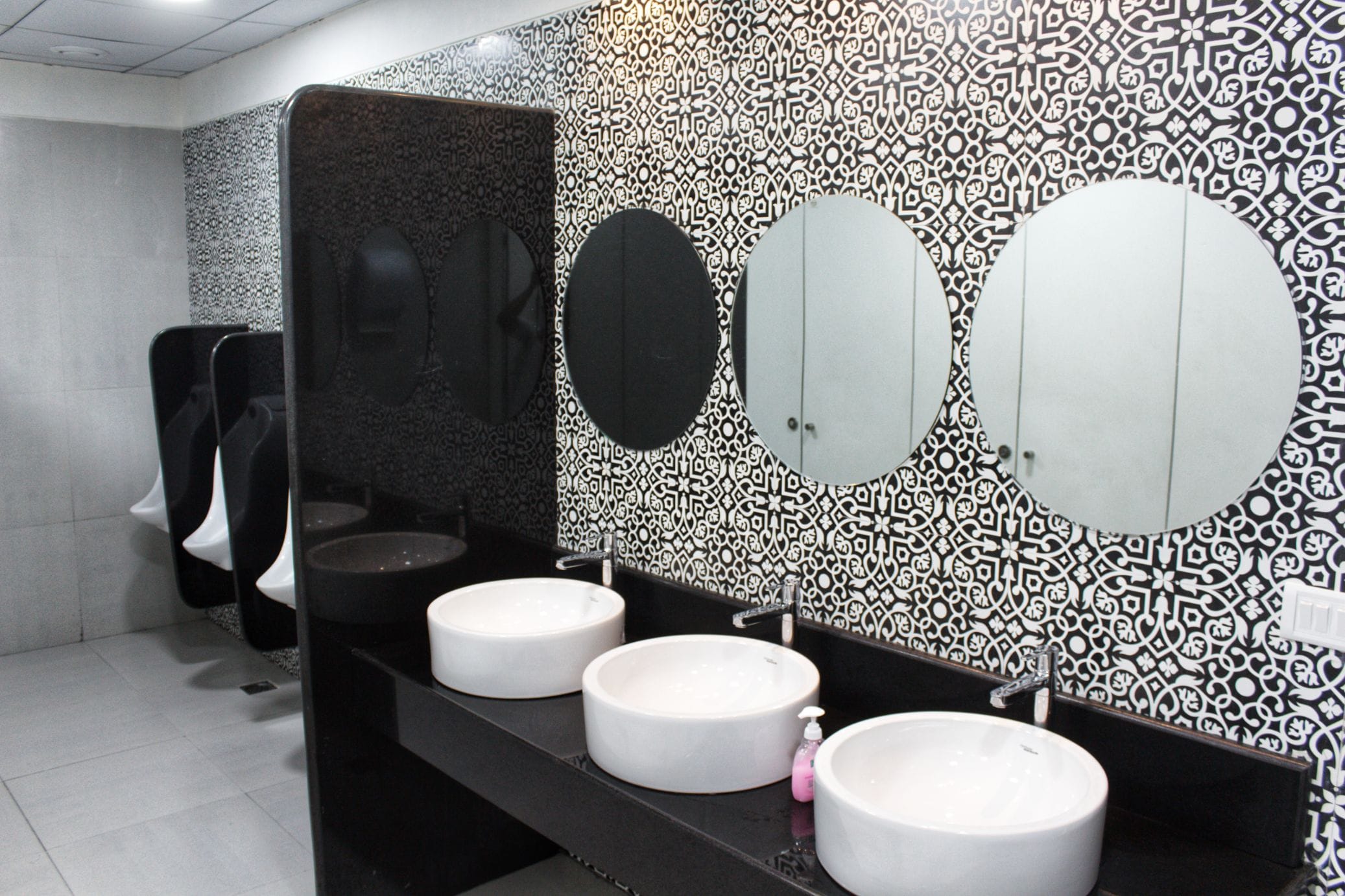 Washroom with sinks and urinals at Temenos office