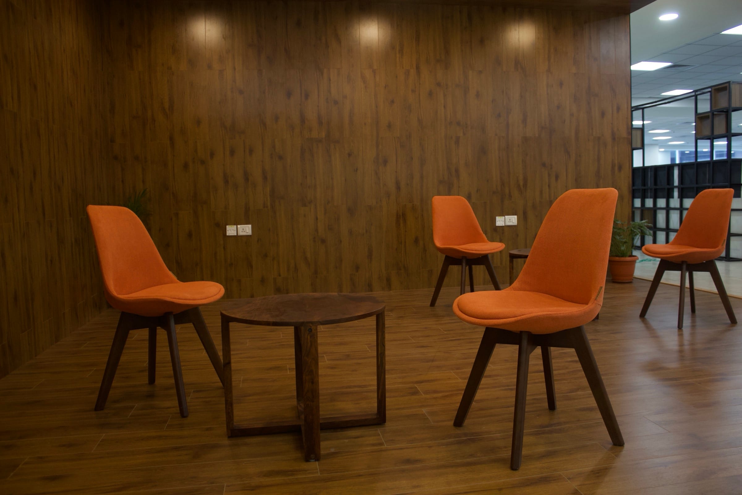 Breakout area with wooden flooring and orange chair, Temenos office
