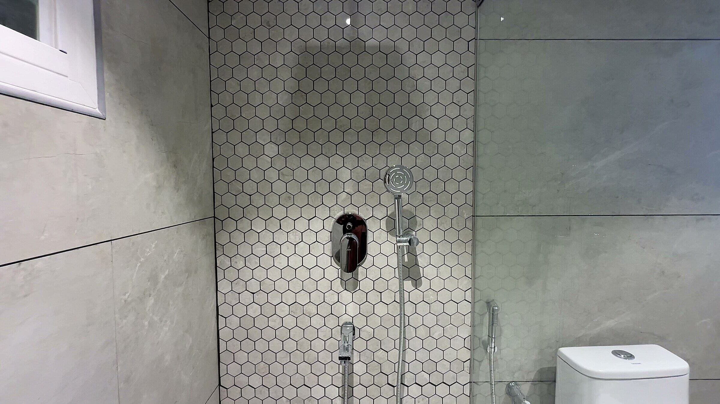 Second bathroom with patterned shower wall tiles at the L13 apartment