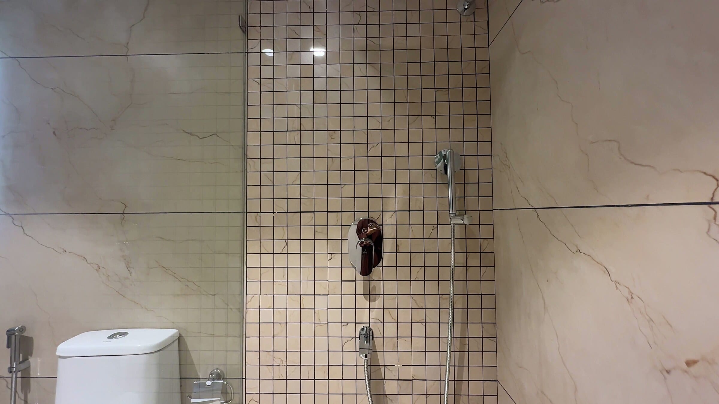 Third bathroom with patterned shower wall tiles at the L13 apartment