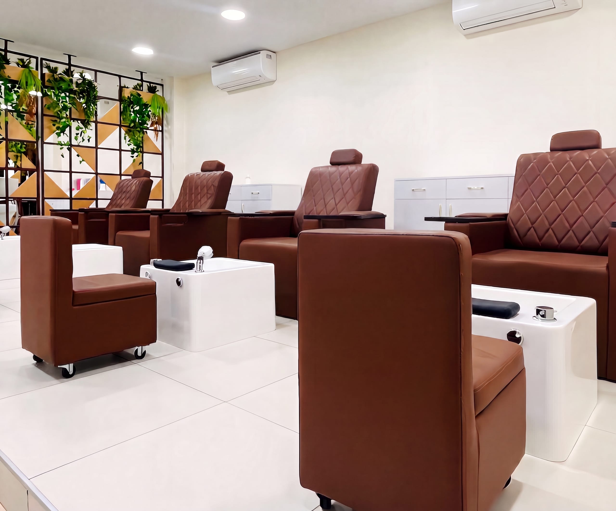 Pedicure station row with foot-spa basins at Amona salon
